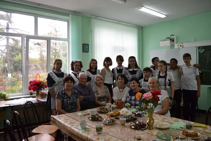 На снимке, в центре стола, изображен Бутко И.Н. Он проводит очередное занятие со слушателями школы основ философских знаний.